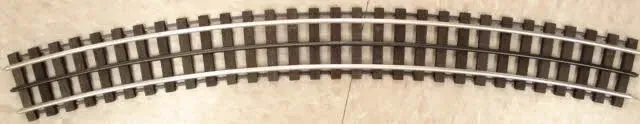 Curved model train track segment on a light background
