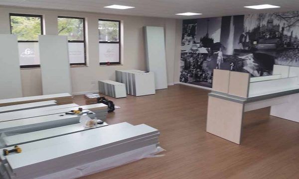Empty office with wood floors, desks, windows, and a black-and-white wall mural
