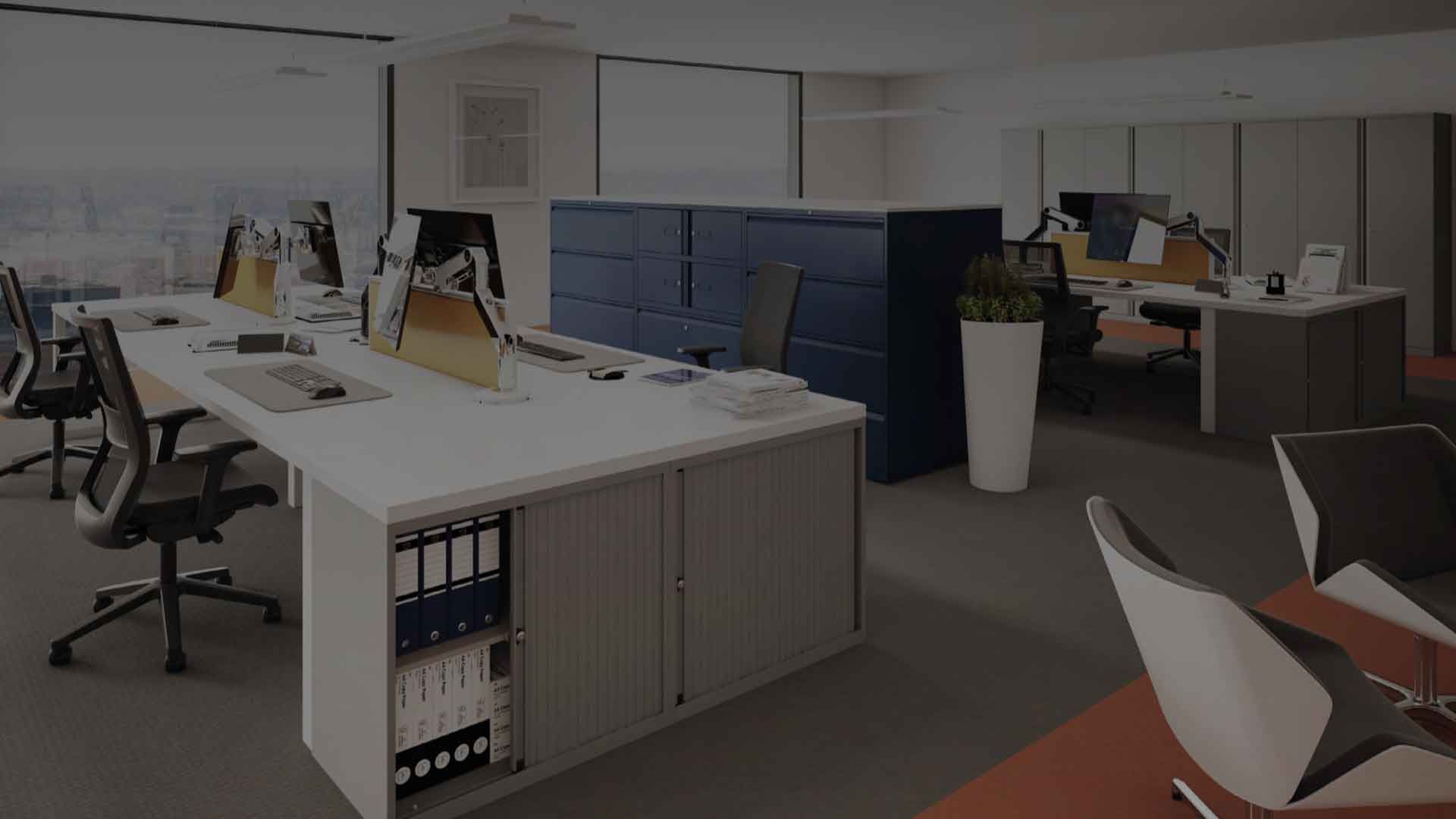 Modern office with desks, computers, chairs, and blue storage cabinets in an open workspace