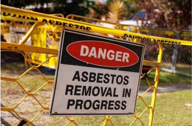 A danger sign that says asbestos removal in progress