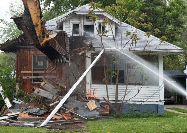 A house is being demolished by a bulldozer.
