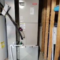 Gray HVAC furnace and water heater in a basement utility area with exposed framing and piping
