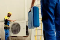 Gray HVAC furnace and water heater in a basement utility area with exposed framing and piping