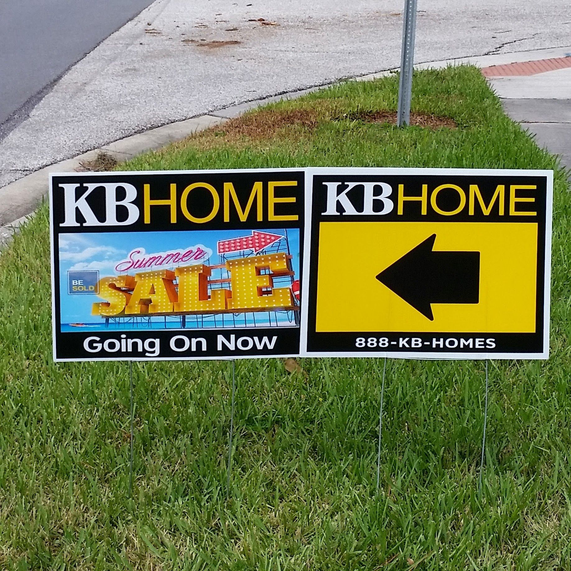 Two kb home signs are sitting in the grass