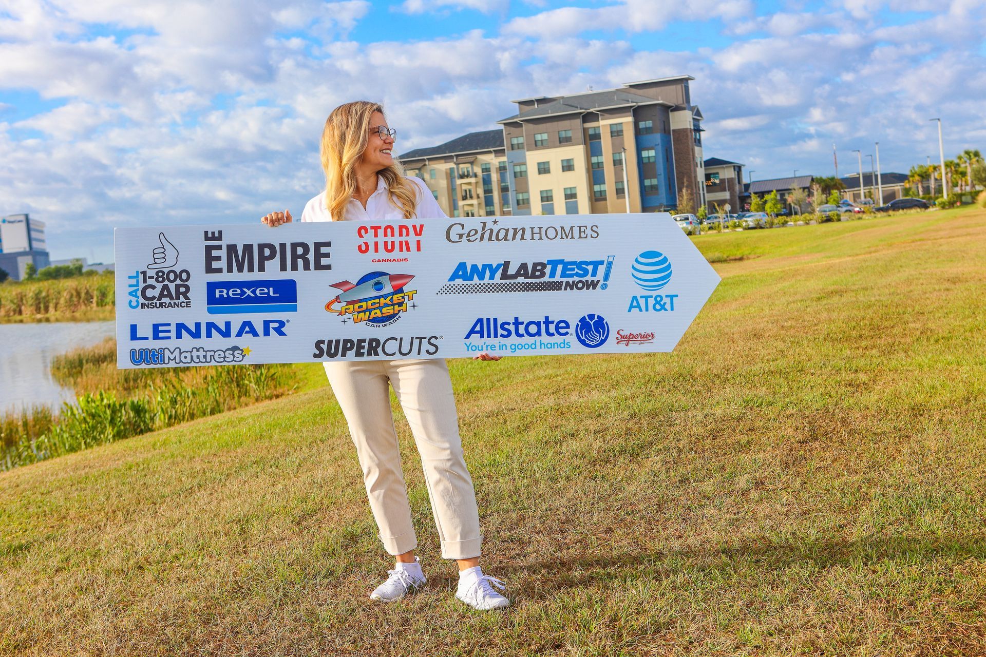 A woman is standing in a field holding a sign that says empire.