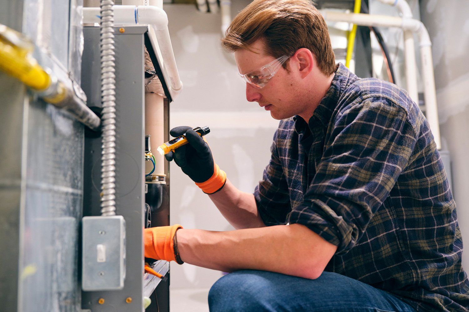 Home Repairman Working on a Furnace | Lafayette, LA | Huval's Heating & Air Conditioning, Inc.