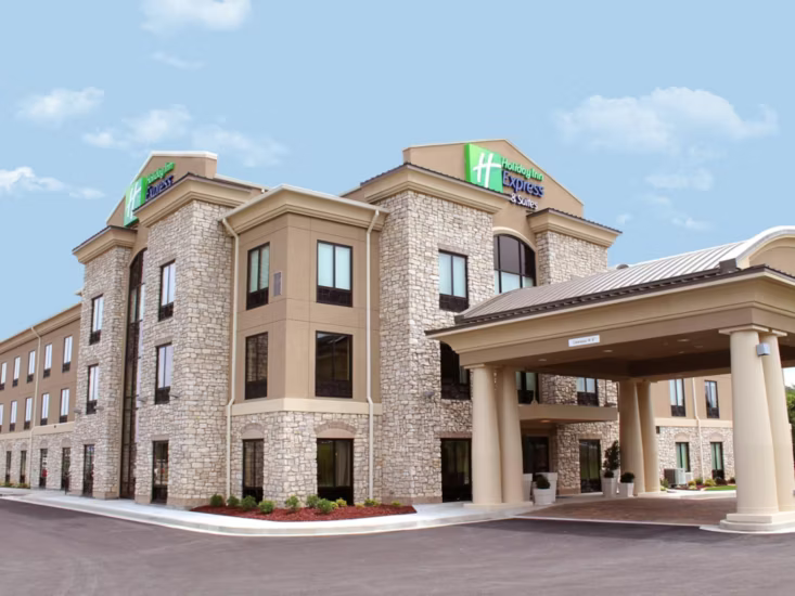 Holiday Inn Express hotel building with stone facade, beige trim, and a covered entrance.