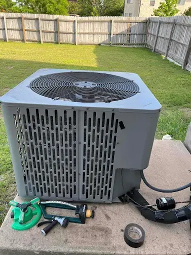 A gray air conditioner is sitting on top of a concrete table.