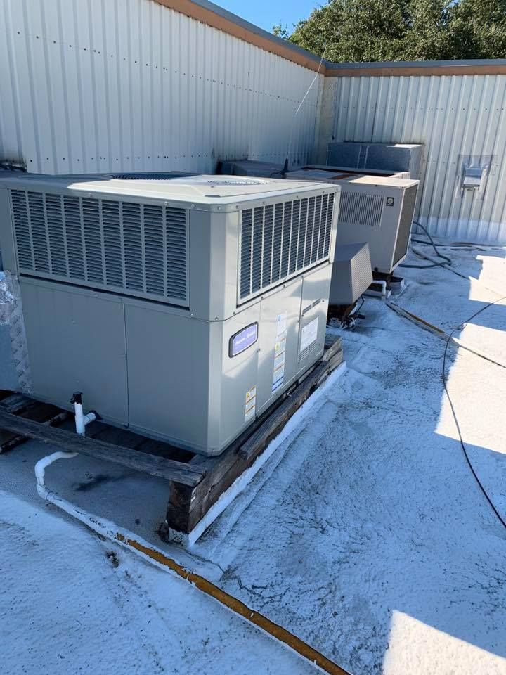 A large air conditioner is sitting on top of a roof.