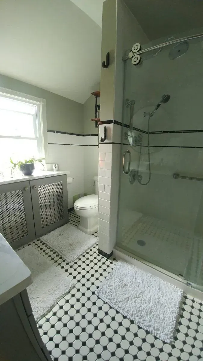 A bathroom with a toilet , sink , and walk in shower.