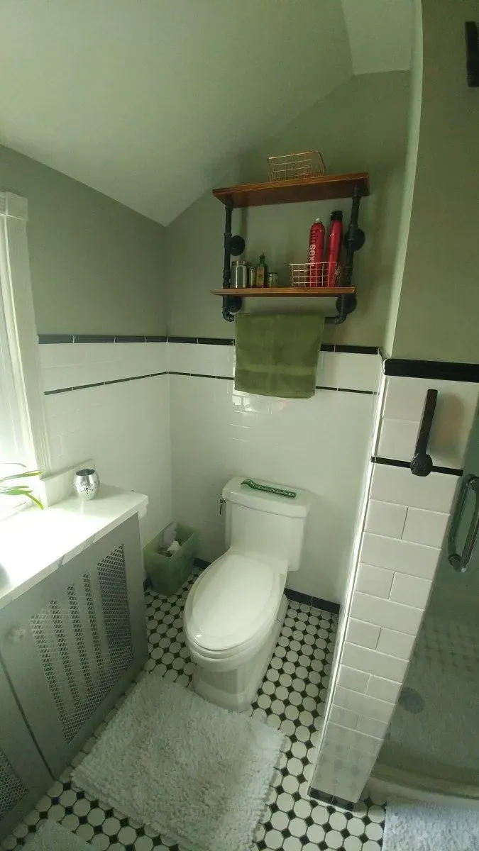 A bathroom with a toilet , sink , and shower.