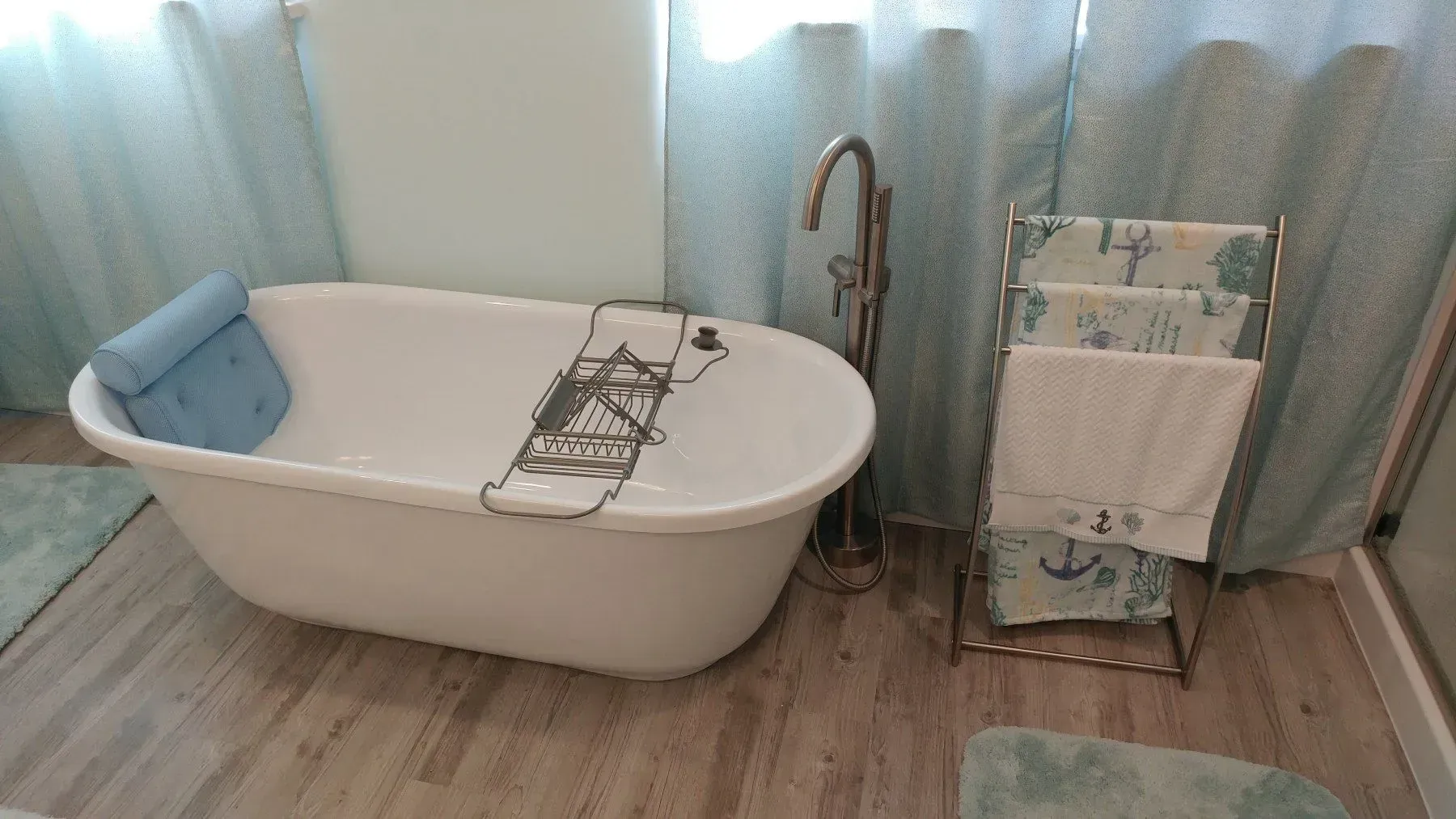 A bathtub is sitting in a bathroom next to a towel rack.