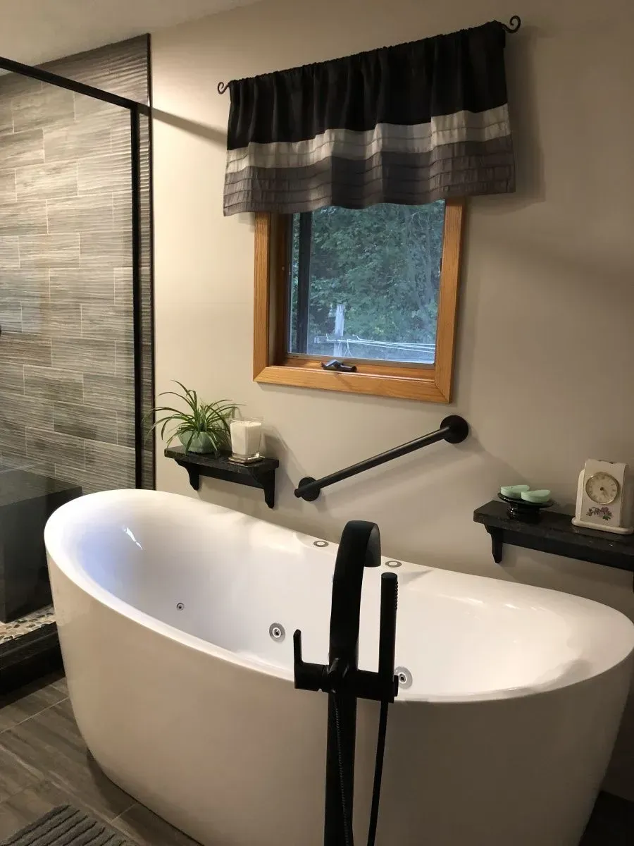 A bathtub in a bathroom next to a window