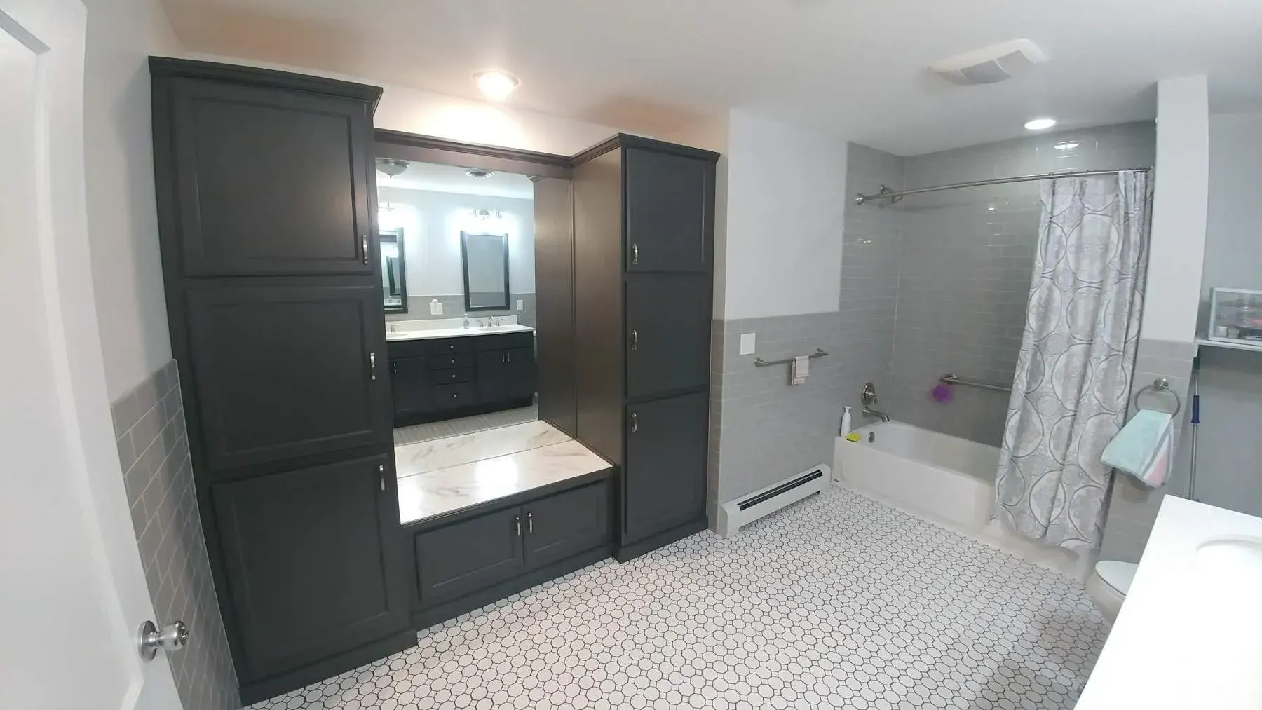 A bathroom with two sinks , a shower , and a bathtub.