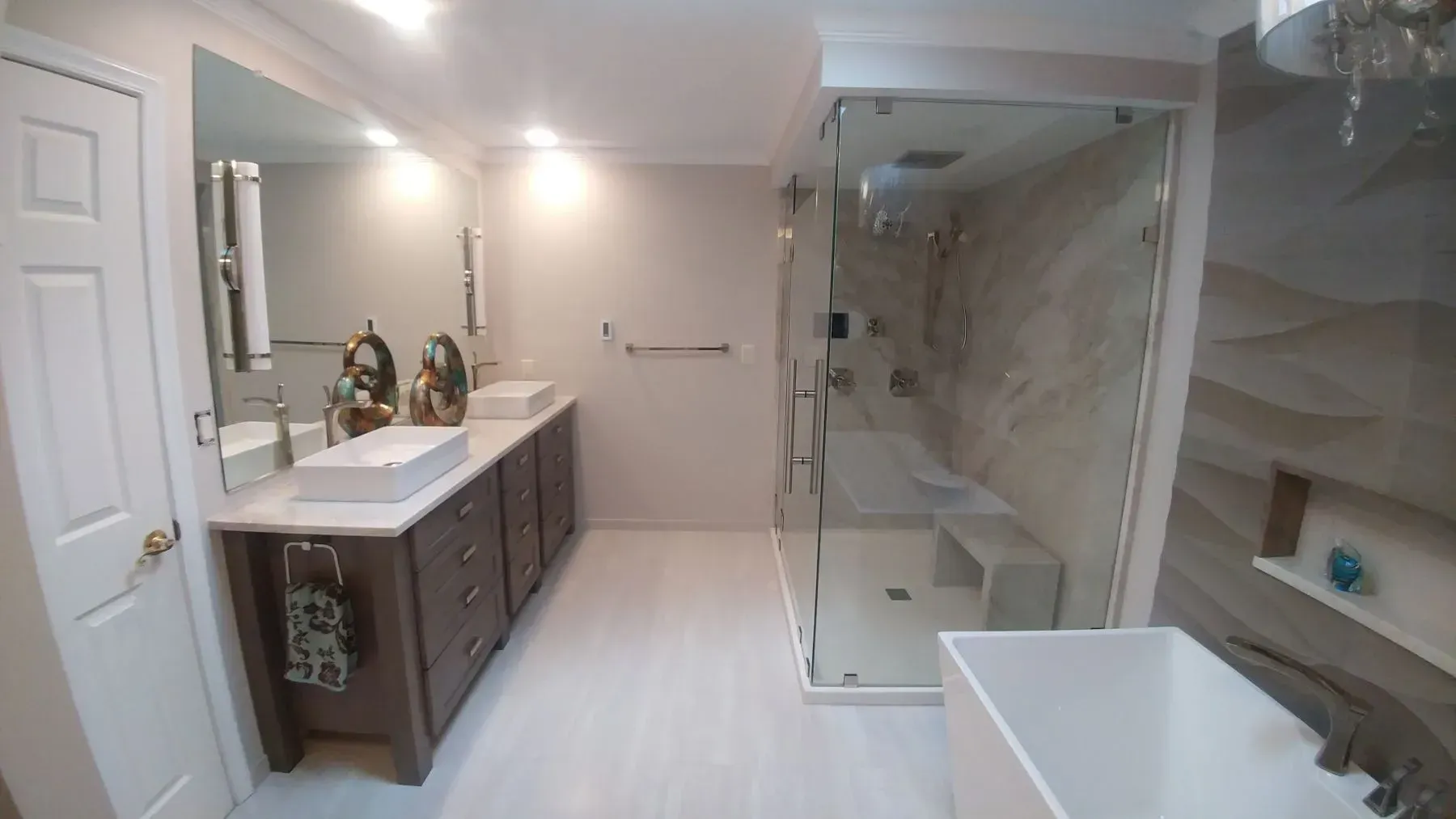 A bathroom with two sinks , a tub and a walk in shower.