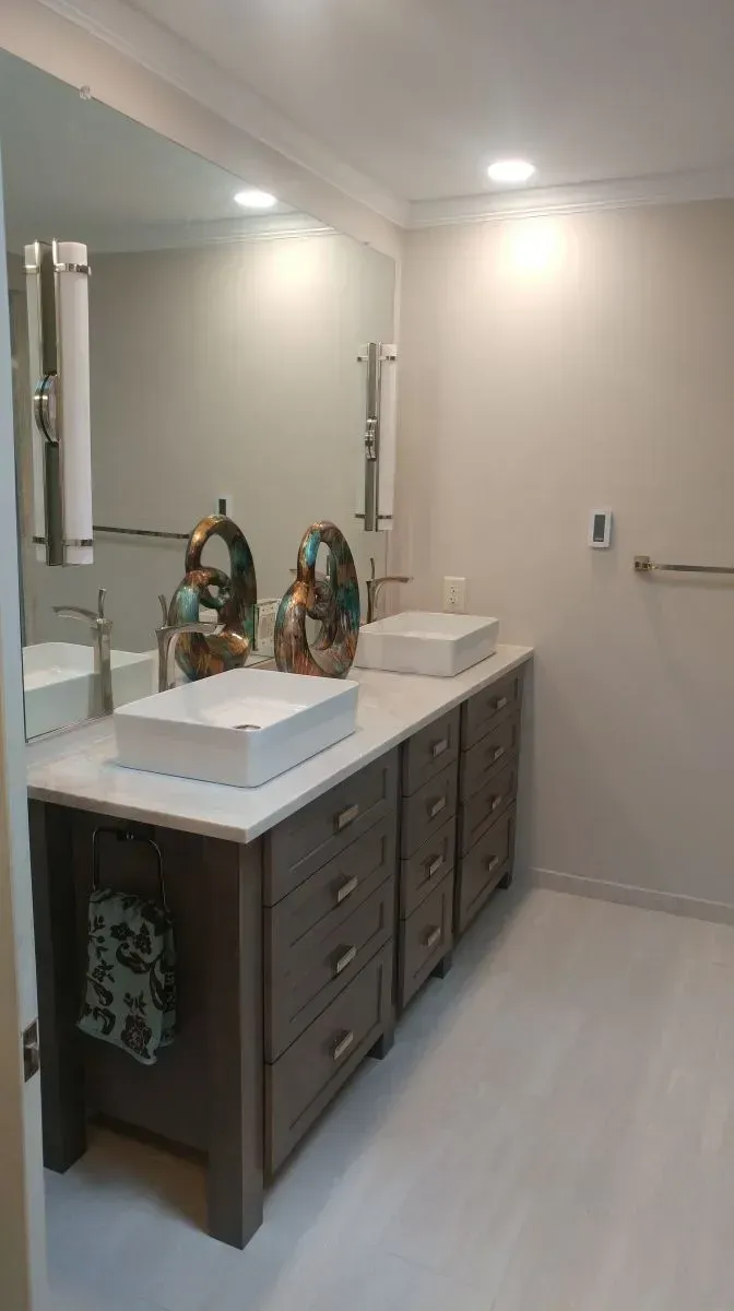 A bathroom with two sinks and a large mirror.