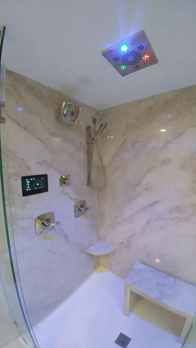 A bathroom with a walk in shower and a bench.