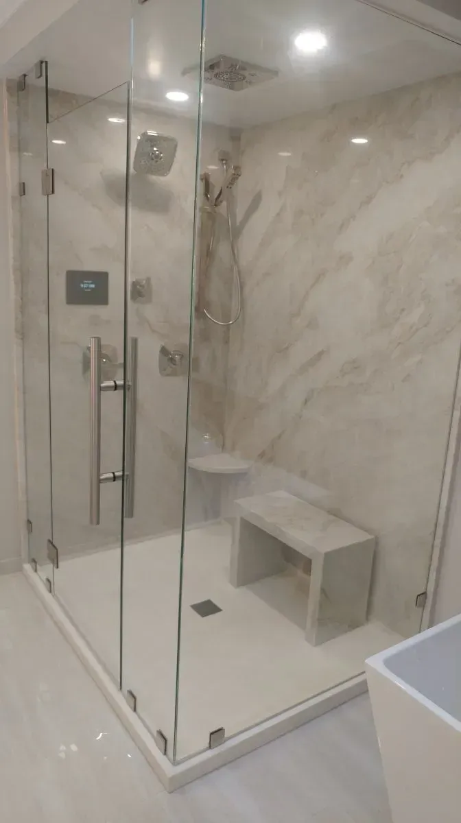 A bathroom with a walk in shower and a bench.