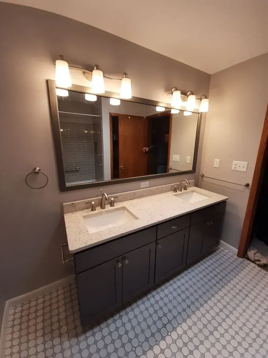 A bathroom with two sinks and a large mirror