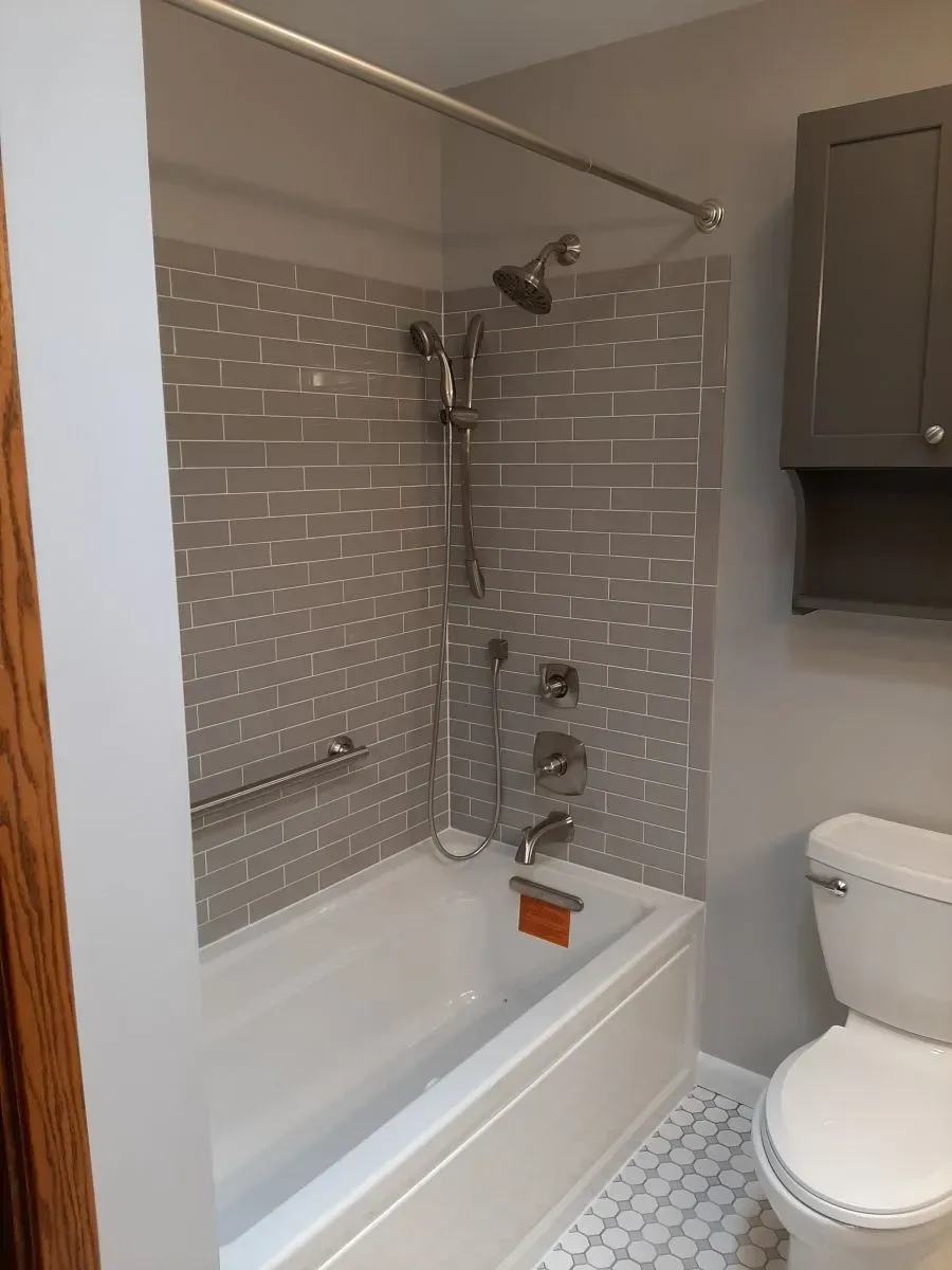 A bathroom with a bathtub , toilet and shower.