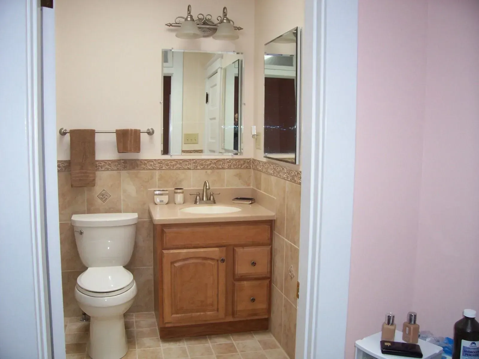 A bathroom with a toilet a sink and a mirror
