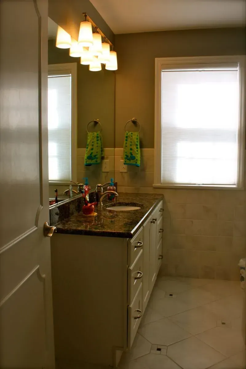 A bathroom with a sink a mirror and a window