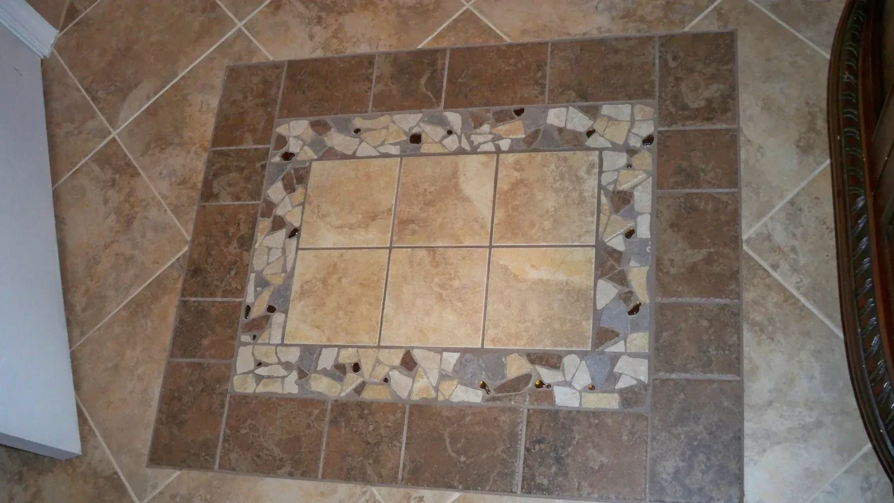 A tiled floor with a mosaic design in the middle