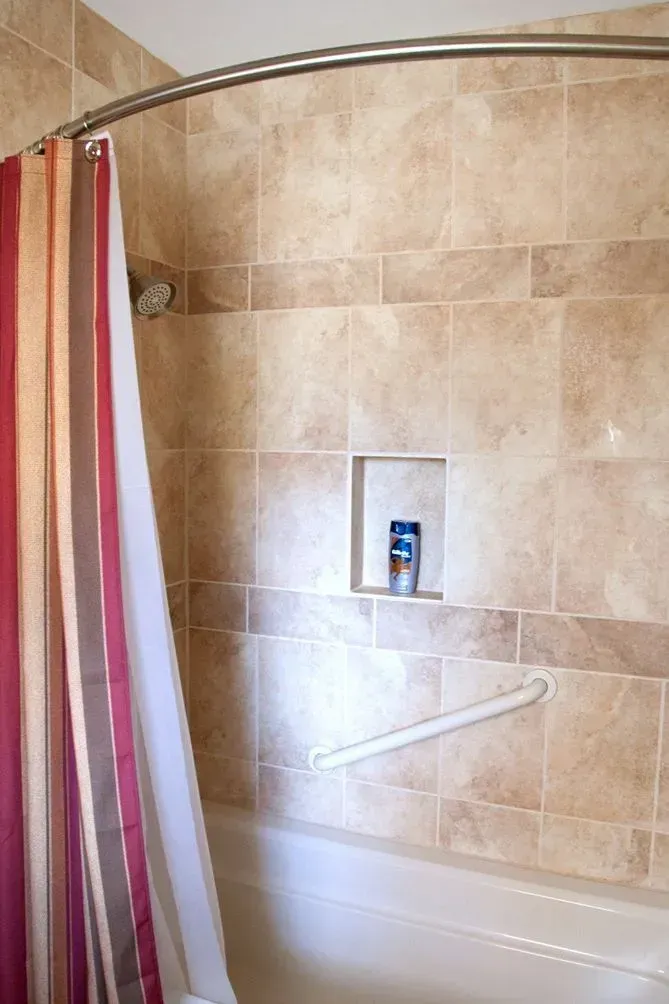 A bathroom with a bathtub and a shower curtain