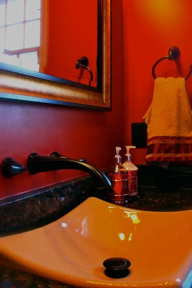 A bathroom sink with two soap dispensers and a mirror