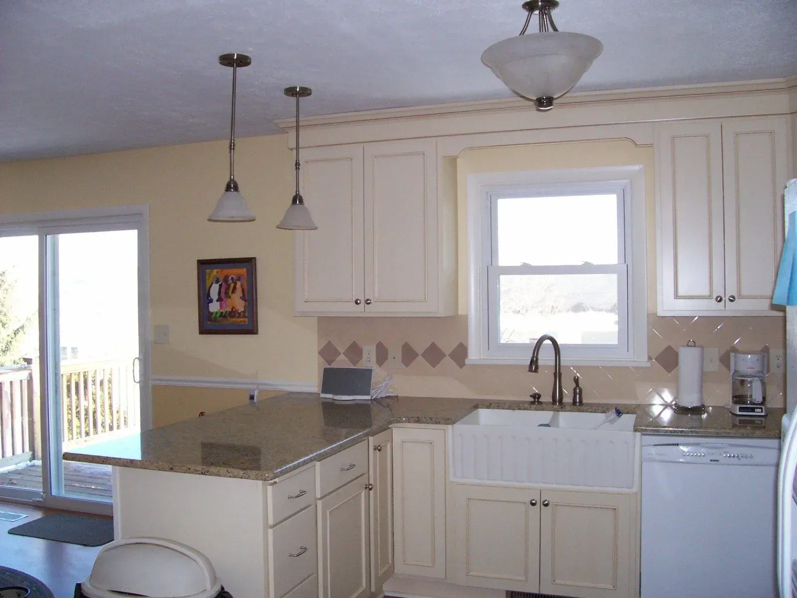 A kitchen with white cabinets and a white sink