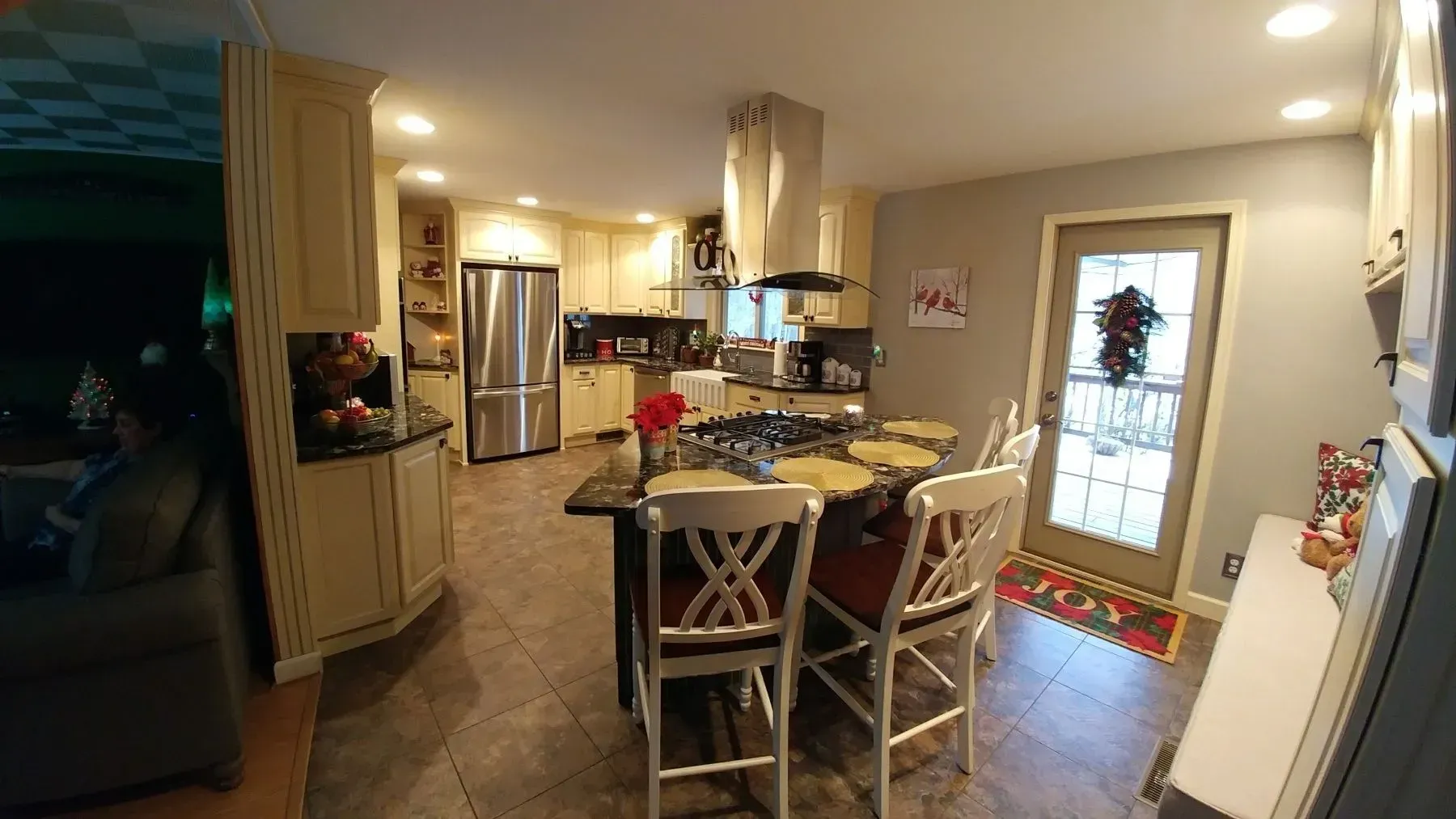 A kitchen with a large island and a stove top oven.
