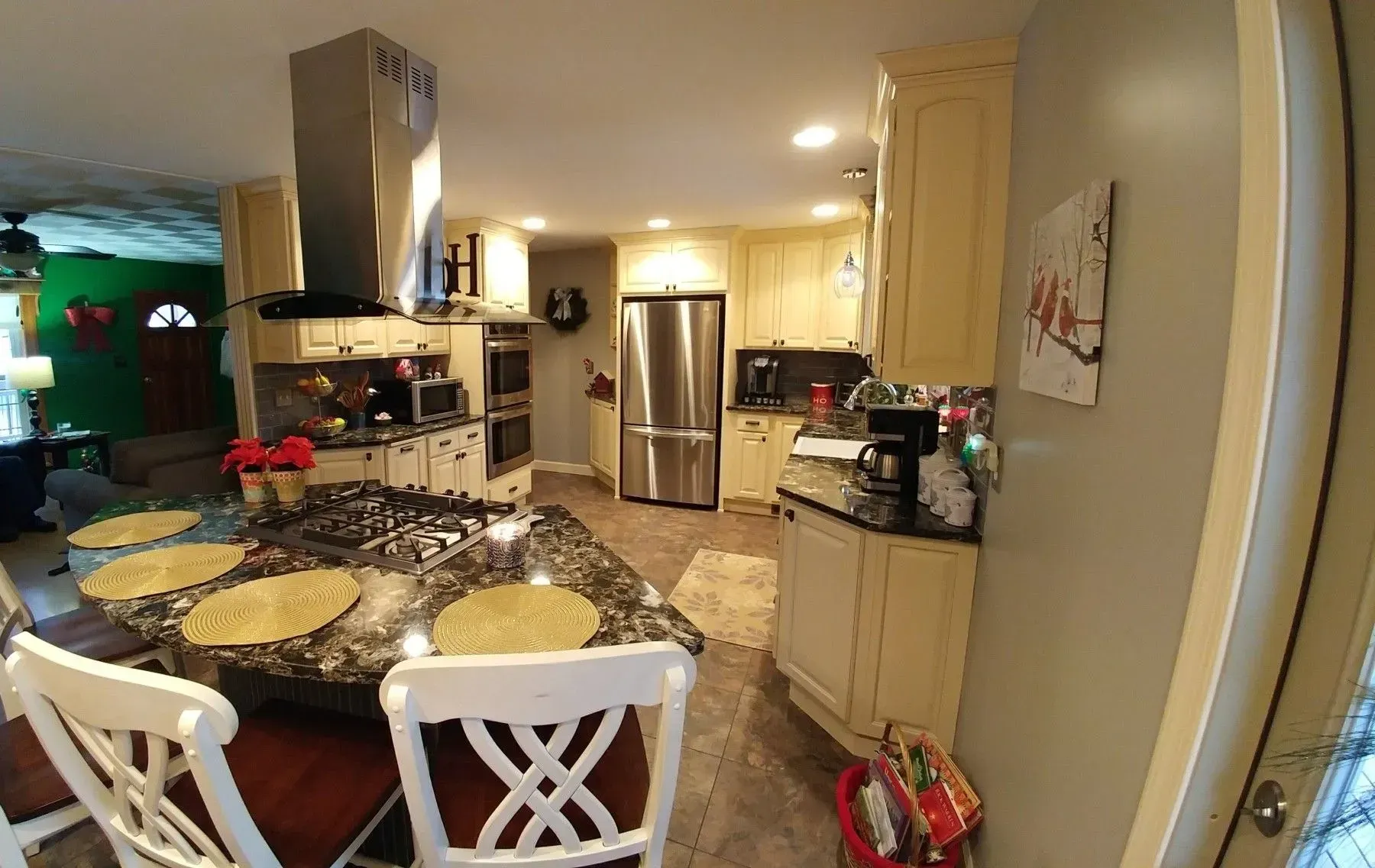 A kitchen with a table and chairs and a stainless steel refrigerator.