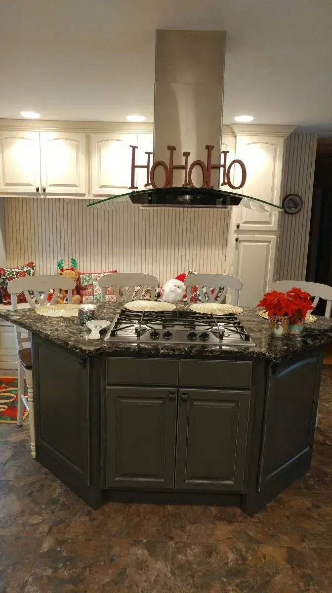 A kitchen with a stove top oven and a hood that says ho ho ho.