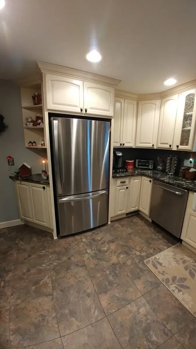 A kitchen with stainless steel appliances and white cabinets.