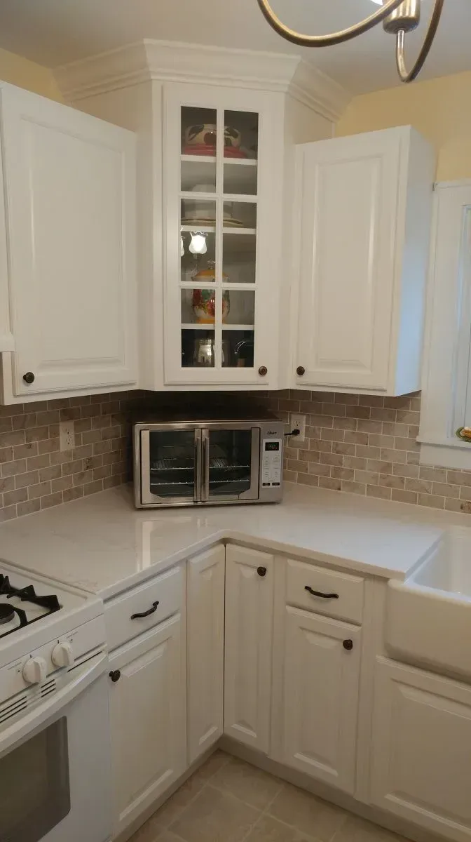 A kitchen with white cabinets and a toaster oven
