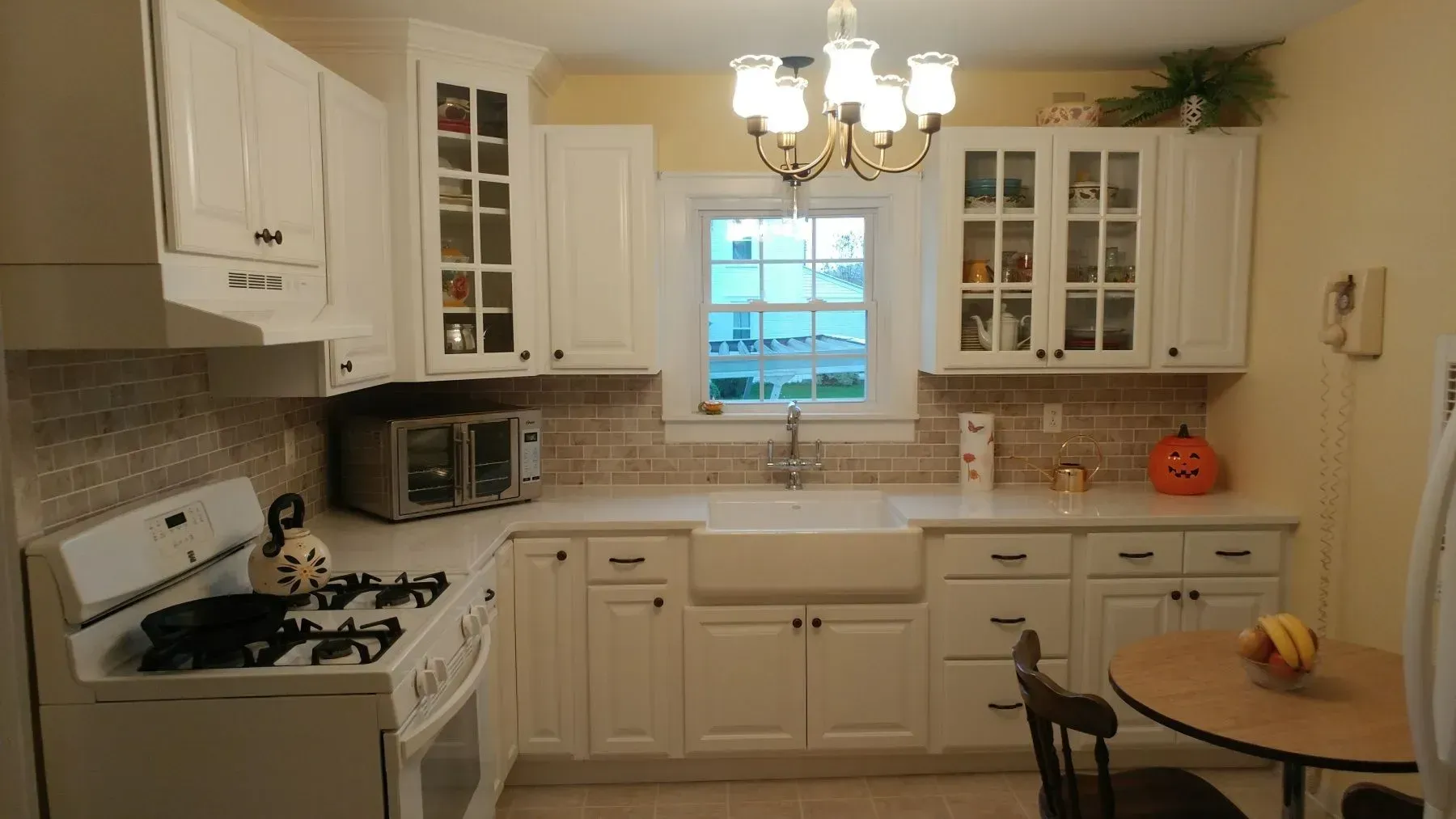 A kitchen with white cabinets and a table and chairs