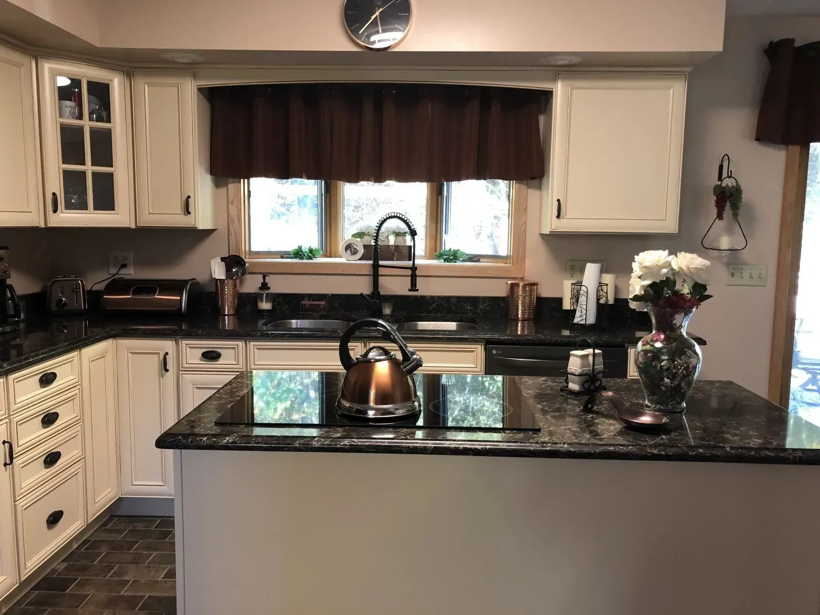A kitchen with white cabinets and black counter tops