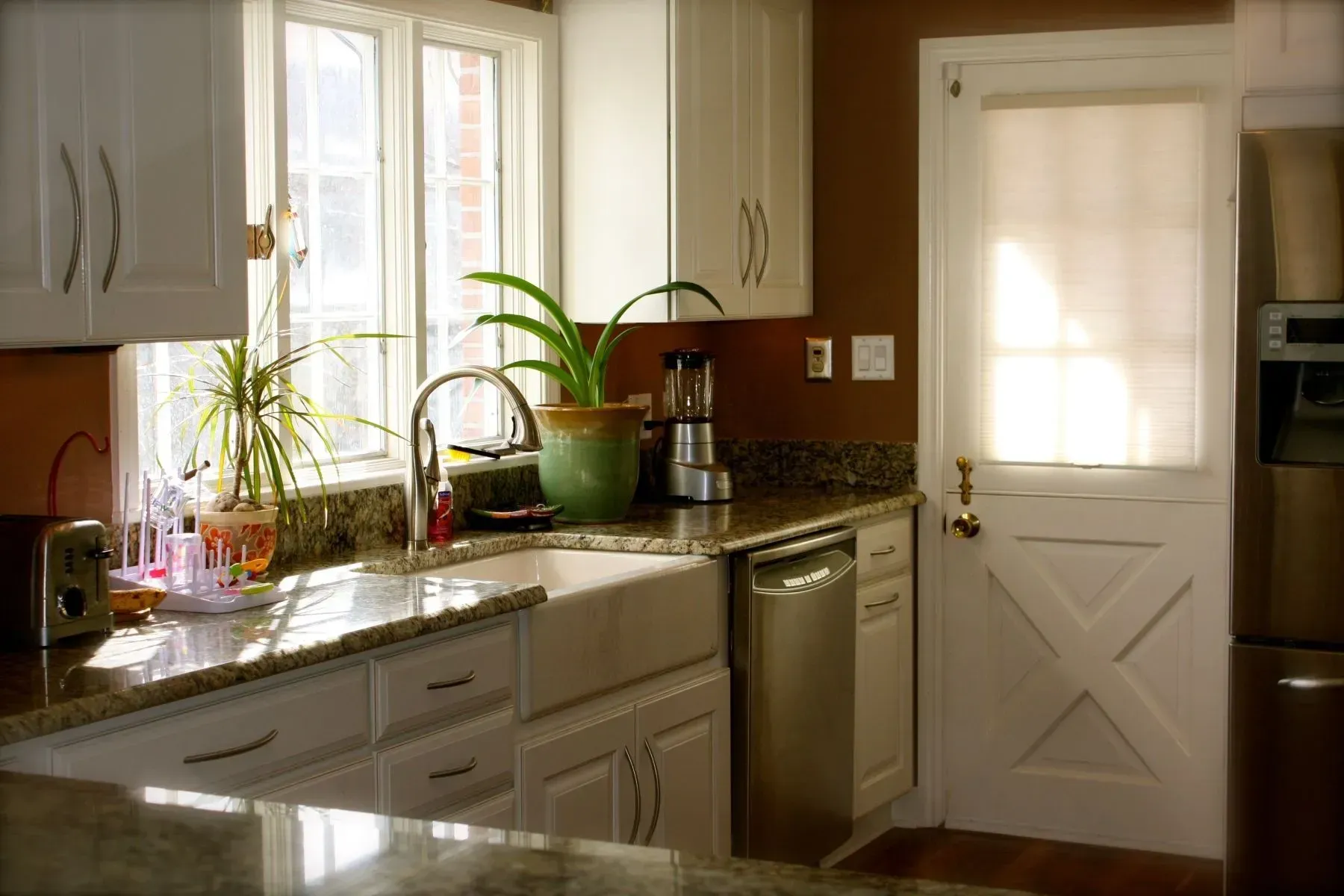 A kitchen with white cabinets and a stainless steel dishwasher
