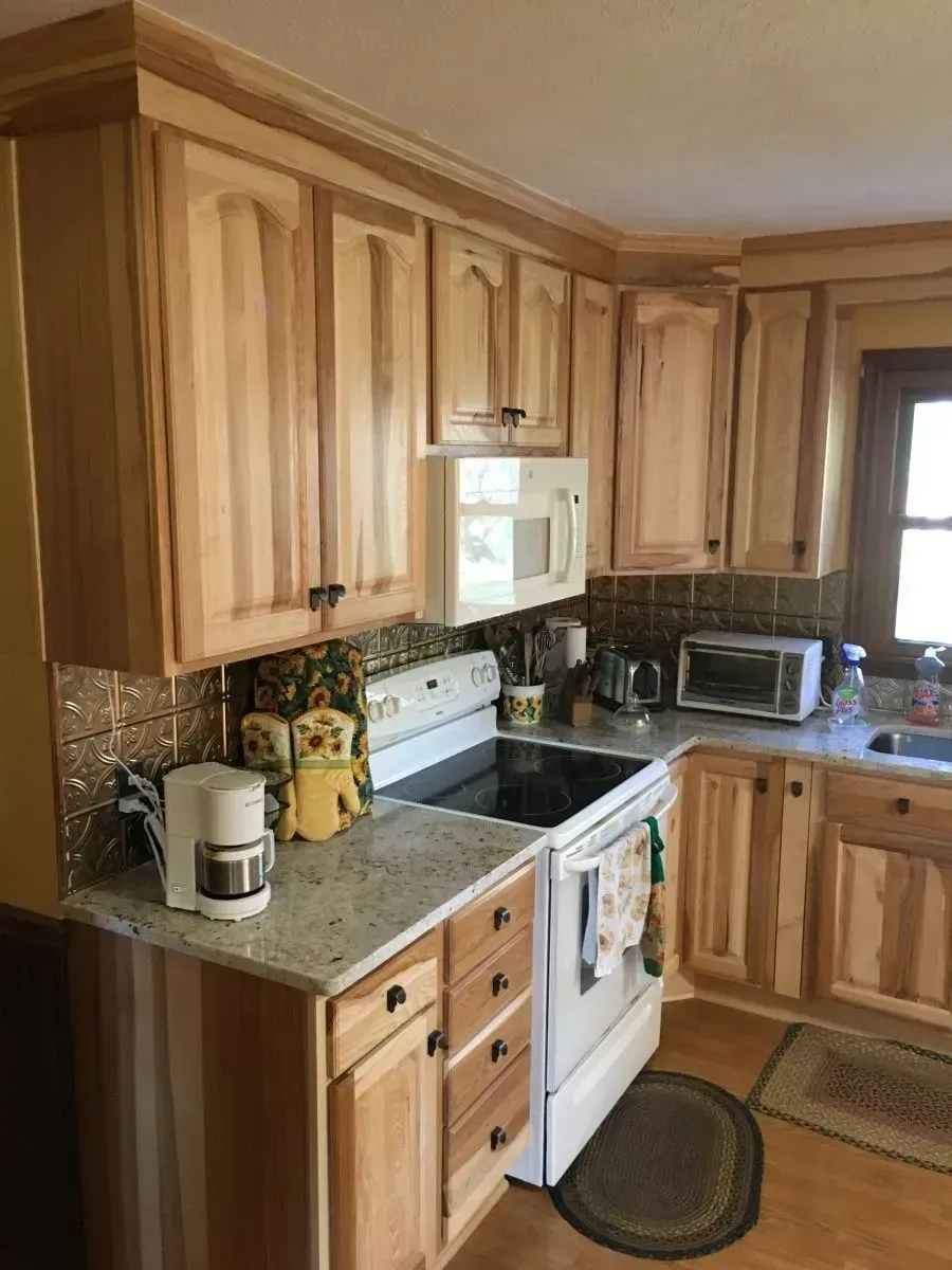 A kitchen with wooden cabinets a stove a microwave and a coffee maker