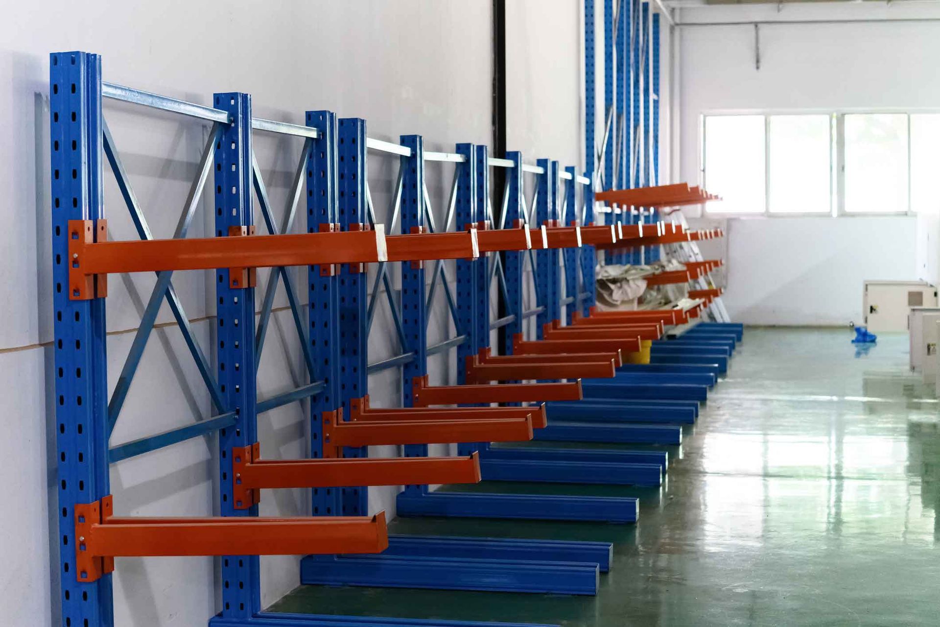 A row of blue and orange shelves in a warehouse.