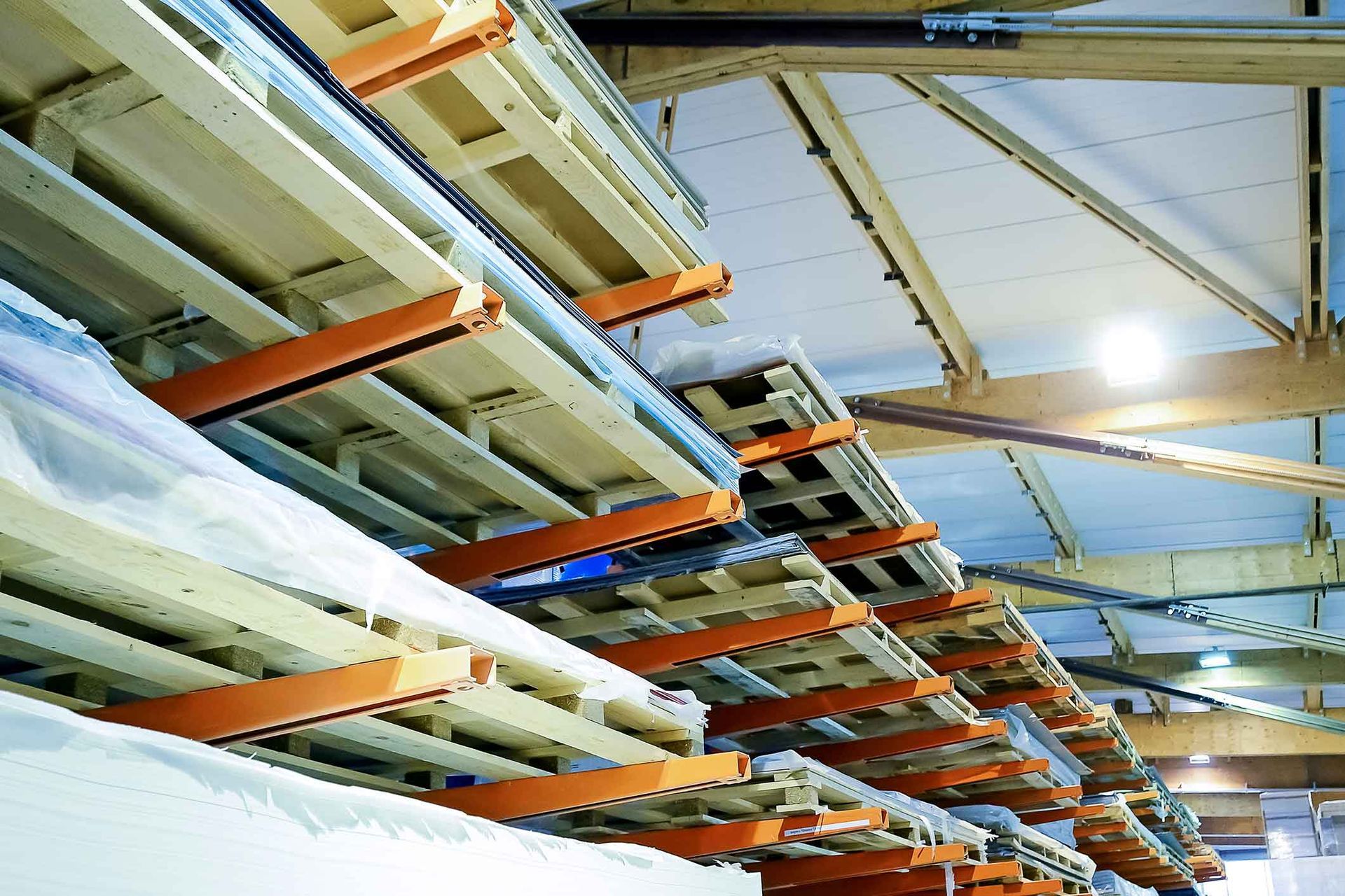 A warehouse filled with lots of pallets and pipes