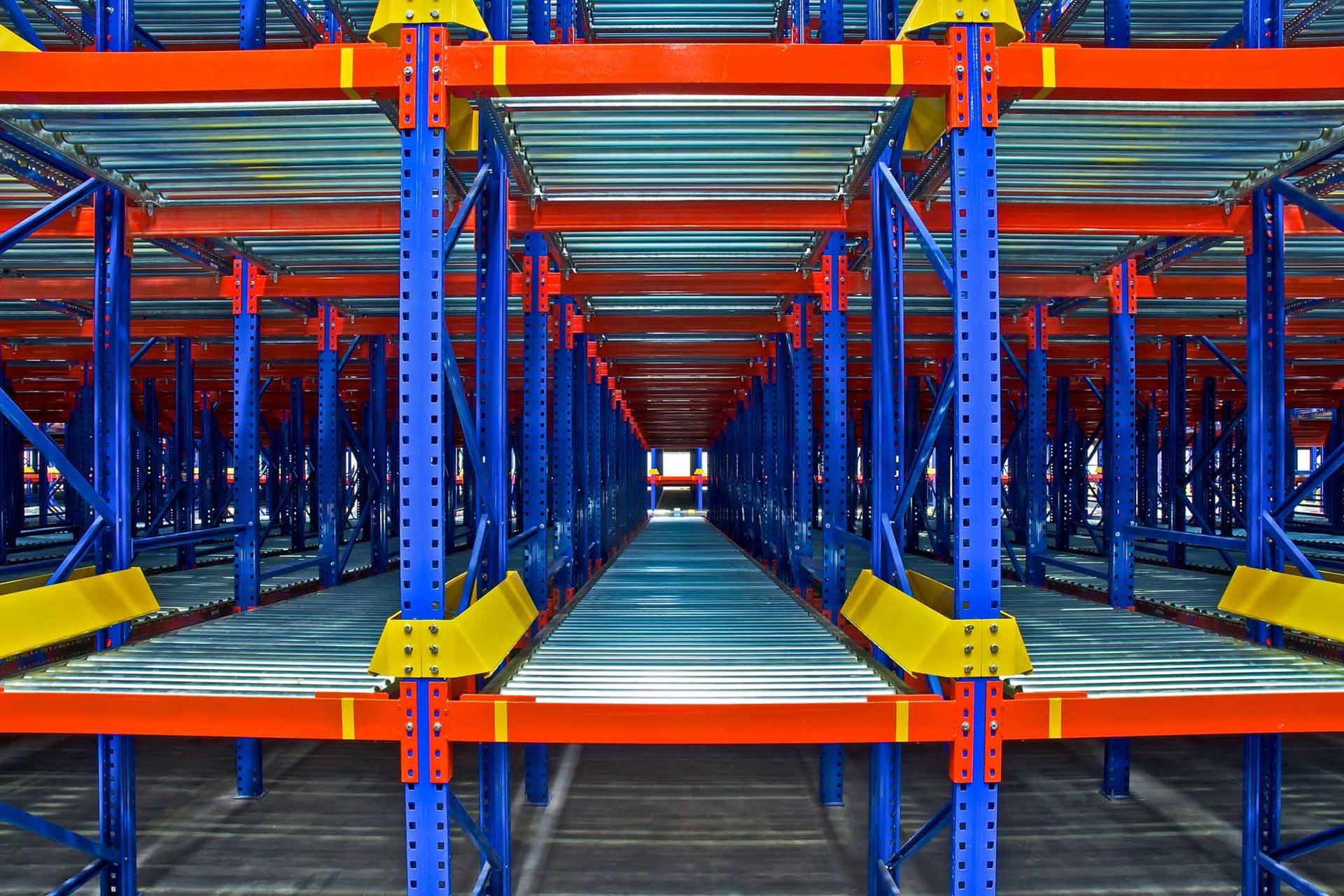 A row of blue and red shelves in a warehouse.