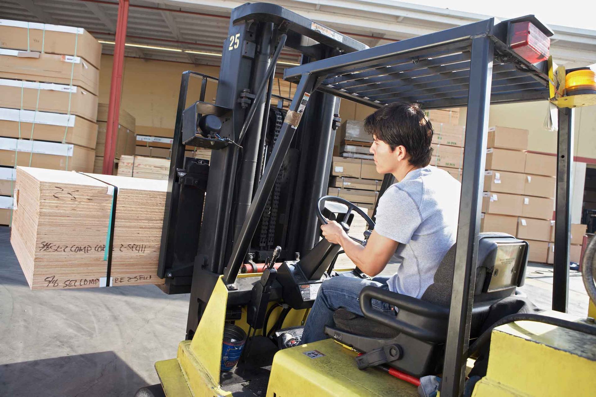 A man is driving a forklift in a warehouse.