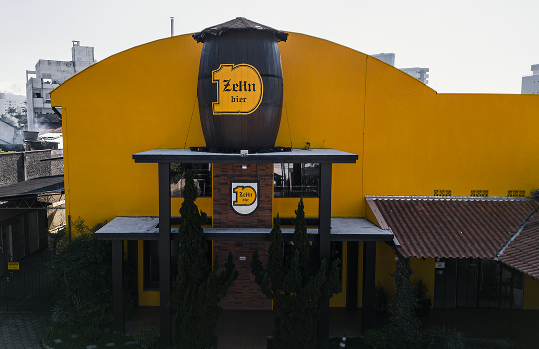 Um prédio amarelo com um grande barril em cima