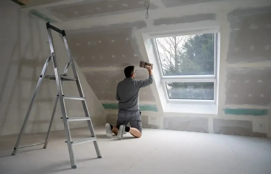 Drywalling a sloped attic ceiling.