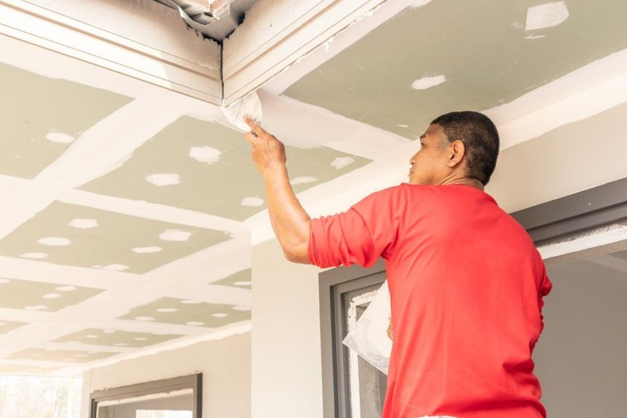 Finishing a drywall ceiling corner.