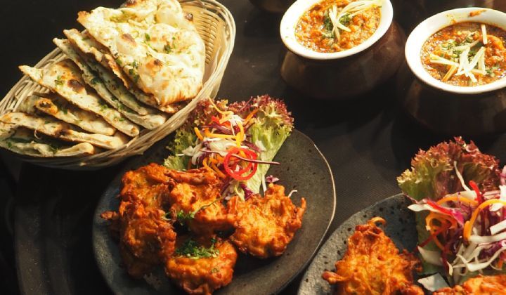 A table topped with plates of food and bowls of soup.