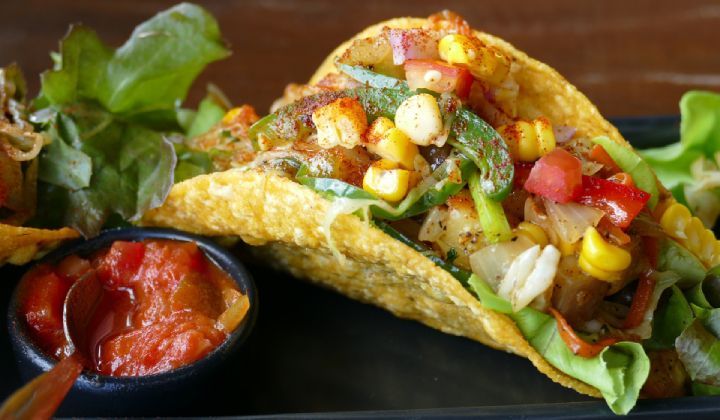 A close up of a taco on a plate with salsa.