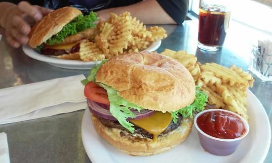 A person is eating a hamburger and french fries at a restaurant