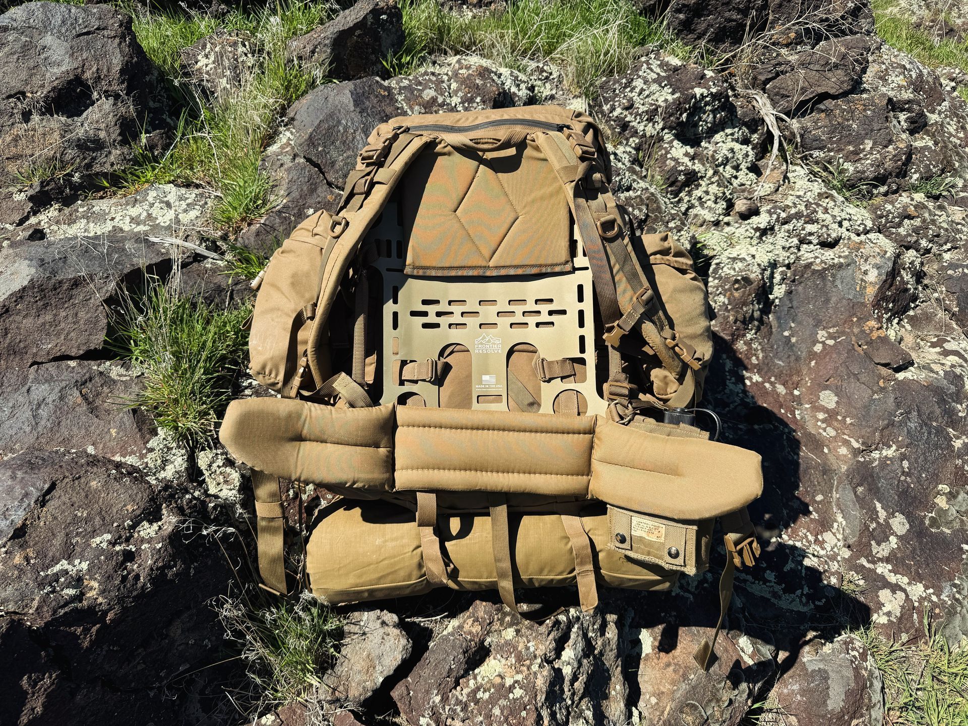 A backpack is sitting on top of a pile of rocks.